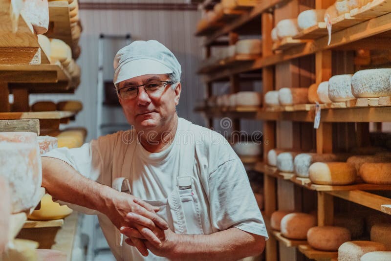 A Worker at a Cheese Factory Sorting Freshly Processed Cheese on Drying