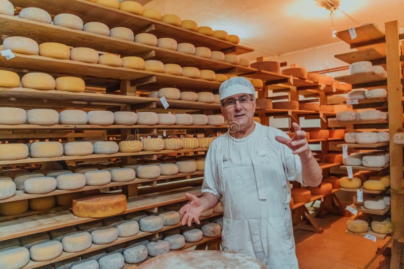 A Worker at a Cheese Factory Sorting Freshly Processed Cheese on Drying