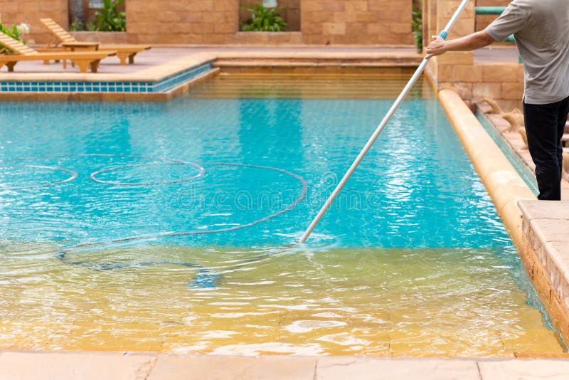 Worker cleaning swimming pool with vacuum tube in the morning. royalty free stock photos Worker cleaning swimming pool with vacuum tube in the morning. royalty free stock photos