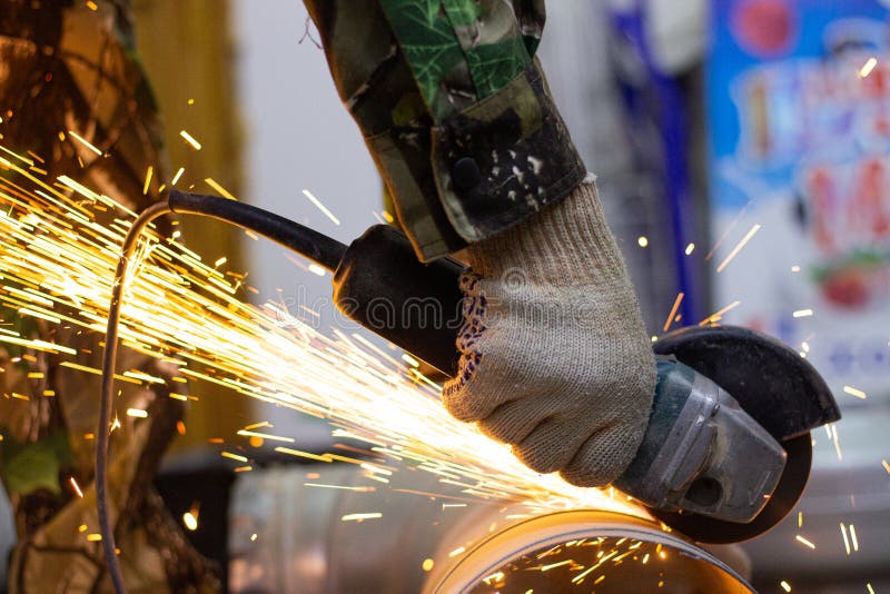 Worker Cuts a Metal Ventilation Pipe with an Angle Grinder Stock Image