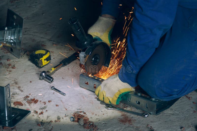 The Worker Cuts Off the Metal with a Grinding Machine. Workflow at the