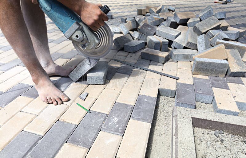 Worker cuts paving slabs for laying on the terrace