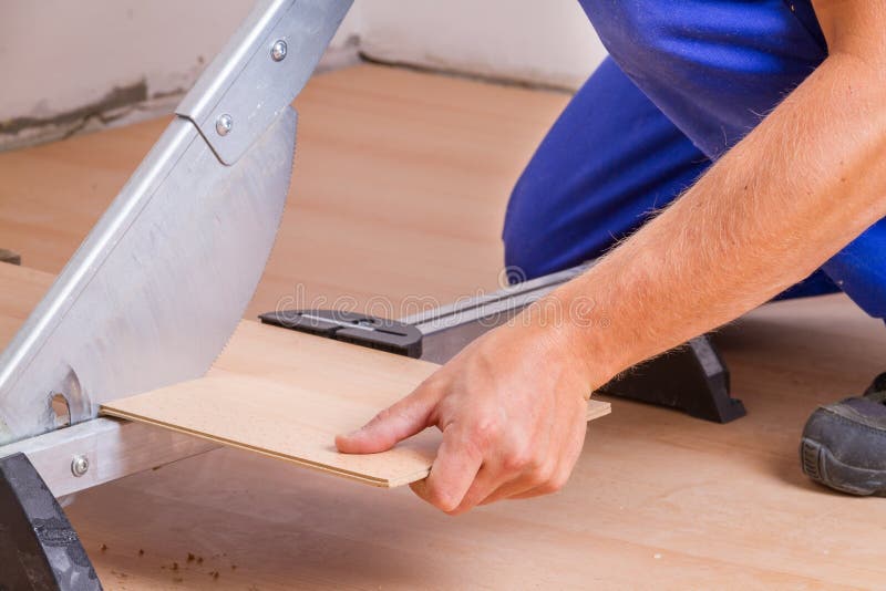 Man Cutting Laminate Floor Boards on Circular Saw, Detail on Hands