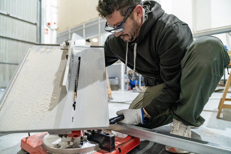 Worker cutting metal profile with circular miter saw royalty free stock photos
