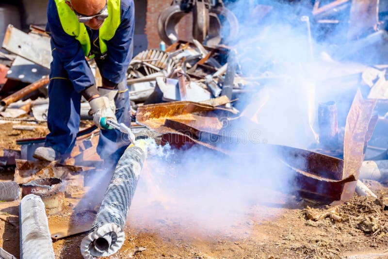 Worker is Cutting Scrap Metal with Acetylene Torch Editorial Stock