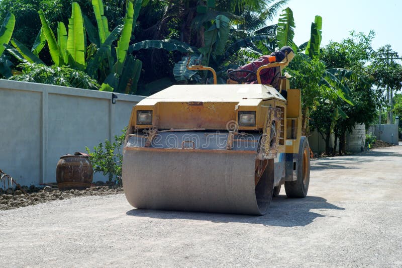 Worker Drives the Road Roller on the Crash Stone Road for Preparaing
