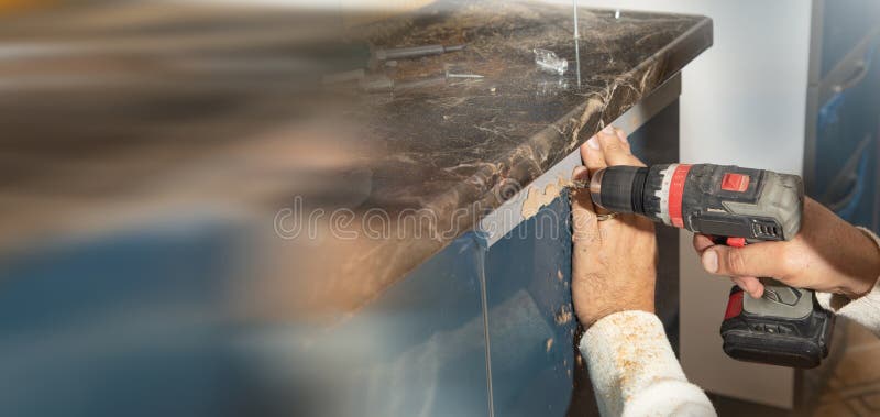 Worker Fixing Kitchen Using Cordless Screwdriver Stock Photo