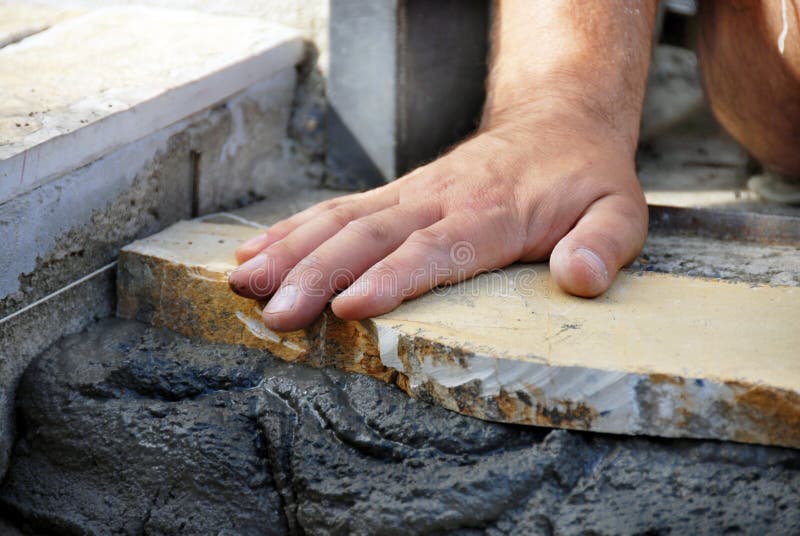 Worker hand on flagstone