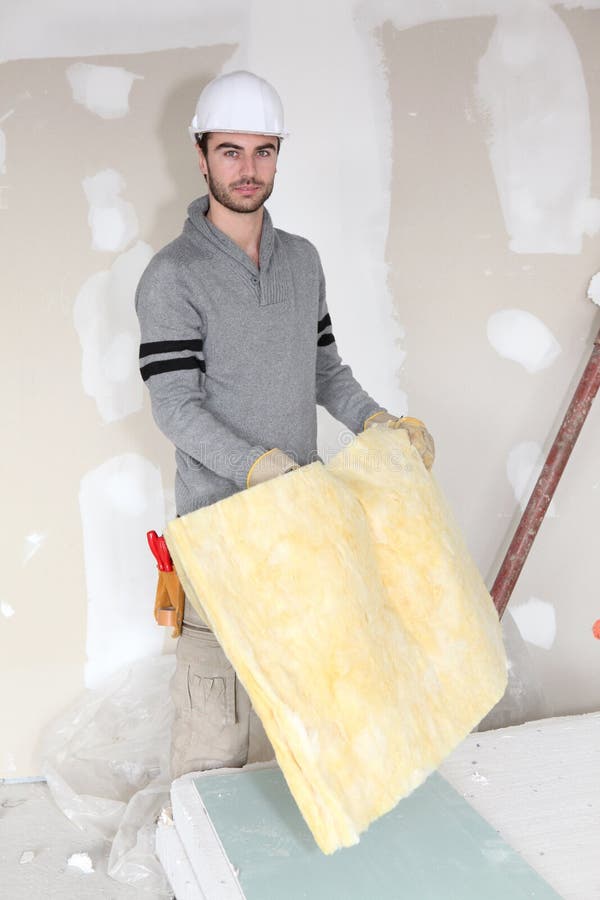Worker handling square of insulation royalty free stock photography