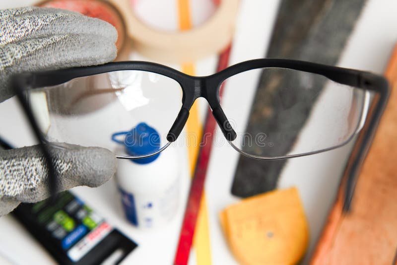 Worker hands with a protective glasses on the tools in the workb