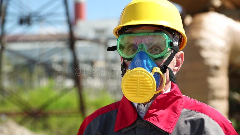 Worker in hard hat, goggles and respirator at power station