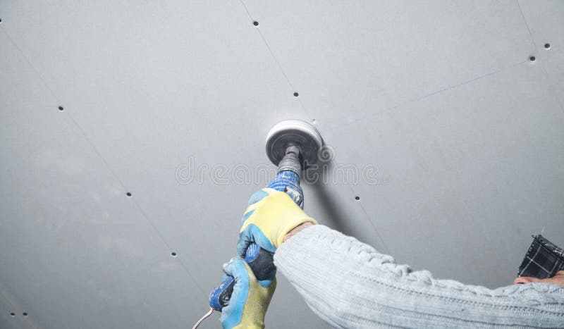 Worker Holding A Power Drill Make A Hole In The Ceiling Install