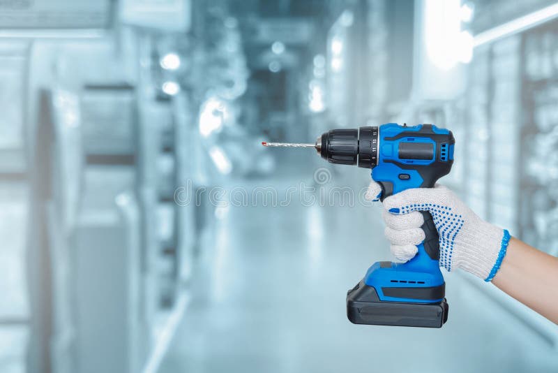 Worker holds a drill in hands stock photo