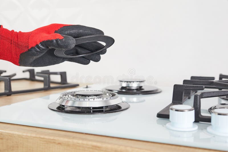 Worker Install Burner on Gas Hob in Kitchen Interior. Repairs of Gas