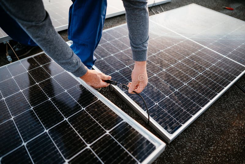 Worker Installing Solar Energy Panels. Connect Two Panel Together Stock