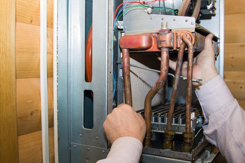 Worker Installs The Heat Exchanger After Descaling On A ...