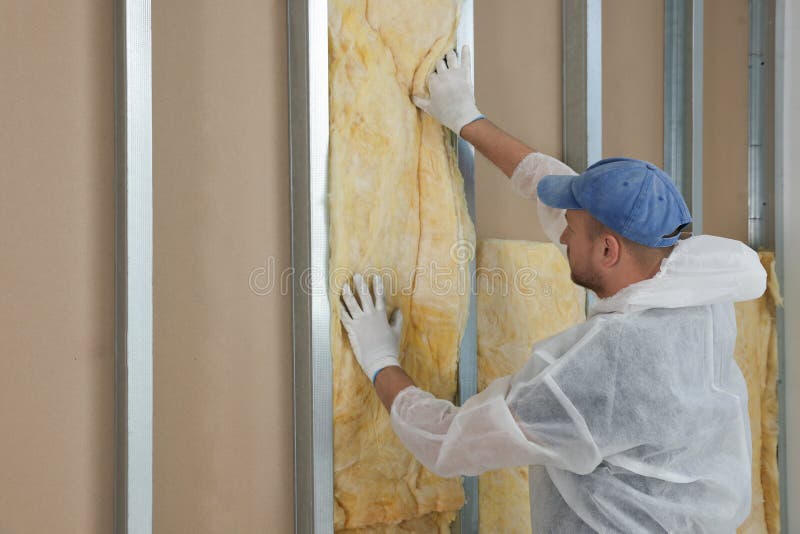 Worker insulating wall indoors. Space for text royalty free stock photography