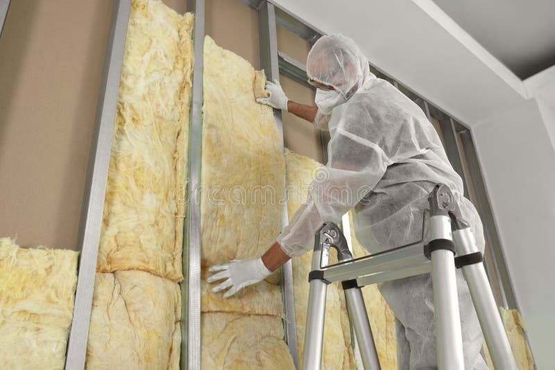 Worker insulating wall using ladder indoors, low angle view royalty free stock photos