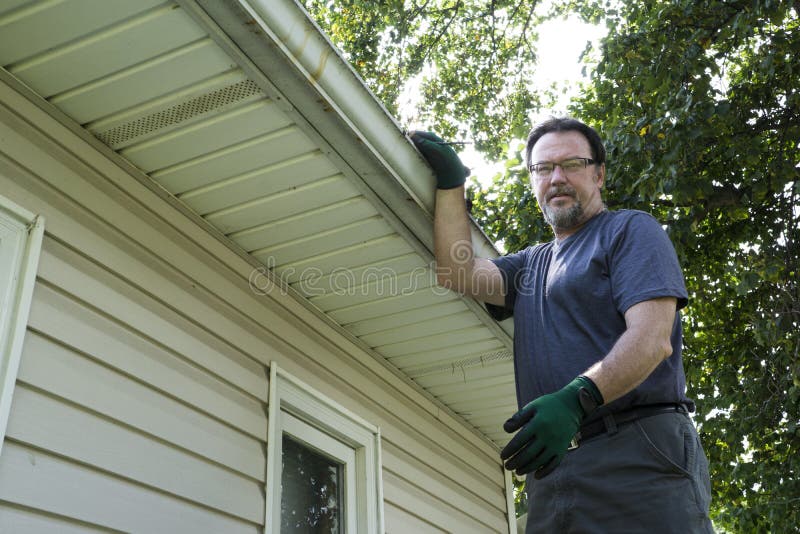 Worker On Ladder Getting Ready To Clean Gutters stock photo Worker On Ladder Getting Ready To Clean Gutters stock photo