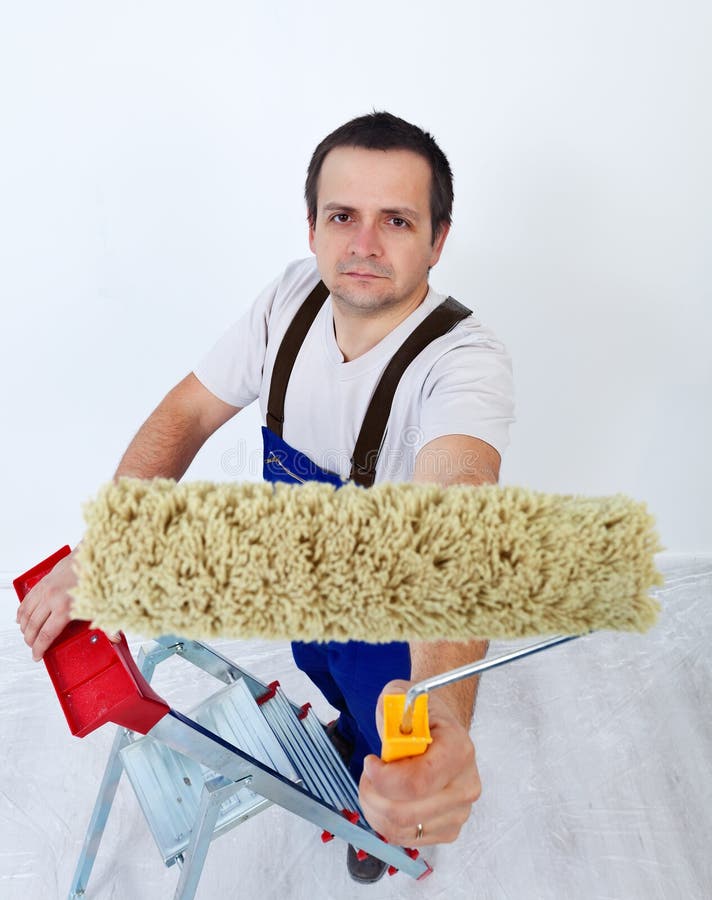 Worker on ladder with paint roller royalty free stock photos