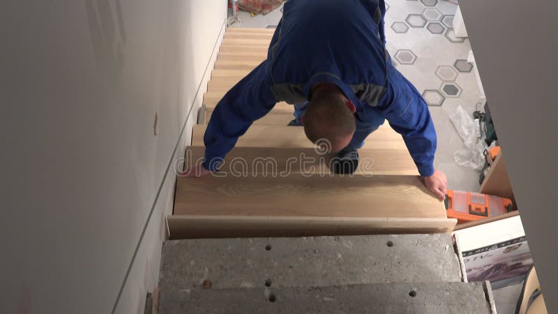 Worker man add stairs board step in staircase
