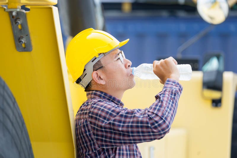 Worker Man in Hard Hat Drinking Water at Containers Cargo Stock Photo