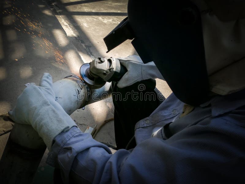 Worker Man in Personal Protective Equipment Grinding Pipe. Stock Image