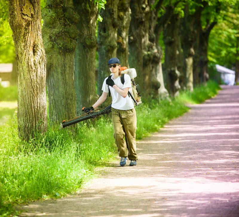 Worker-man processes a park against harvest mite and parasites. royalty free stock photography Worker-man processes a park against harvest mite and parasites. royalty free stock photography