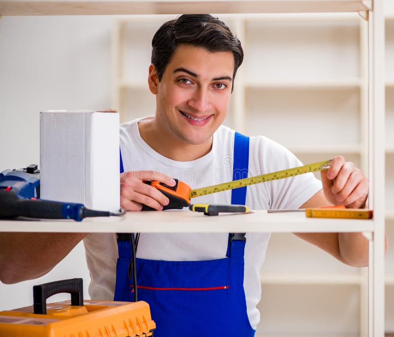 Worker man repairing assembling bookshelf royalty free stock image