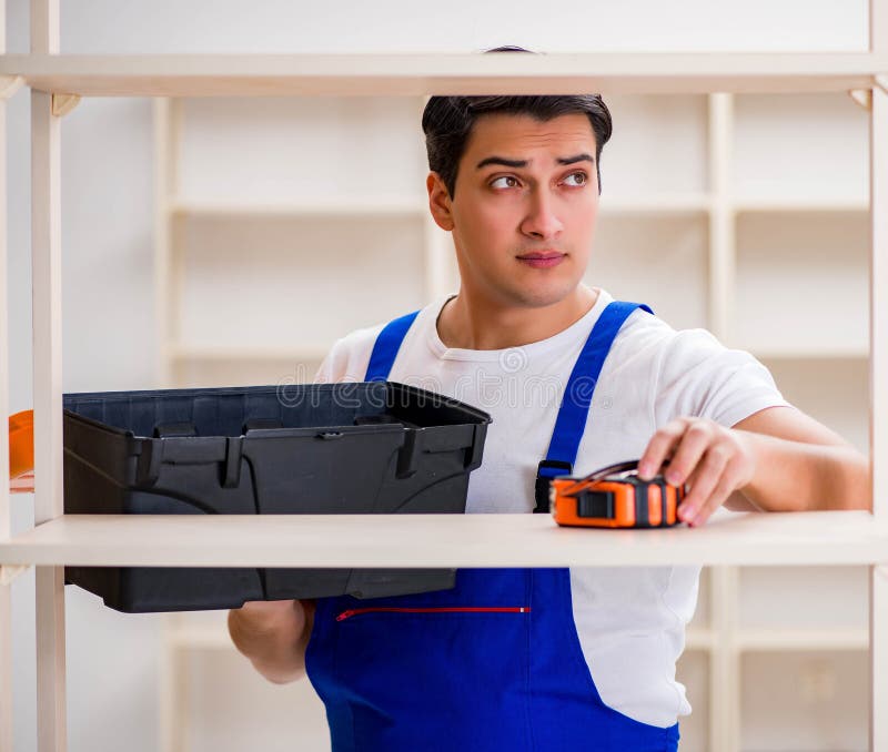 Worker man repairing assembling bookshelf stock photography