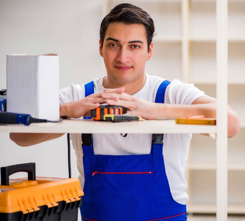 Worker man repairing assembling bookshelf royalty free stock photos