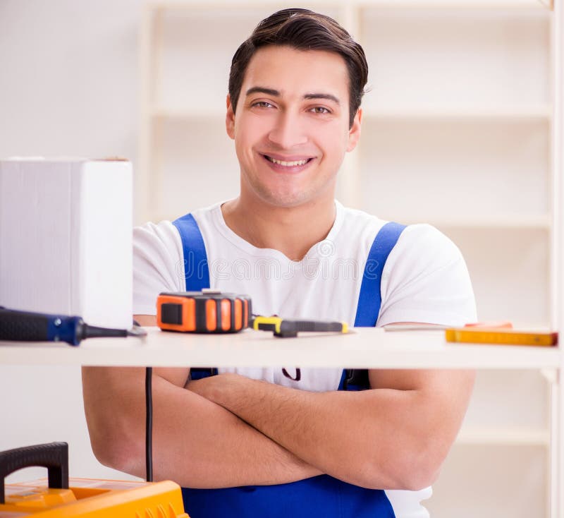 Worker man repairing assembling bookshelf royalty free stock images