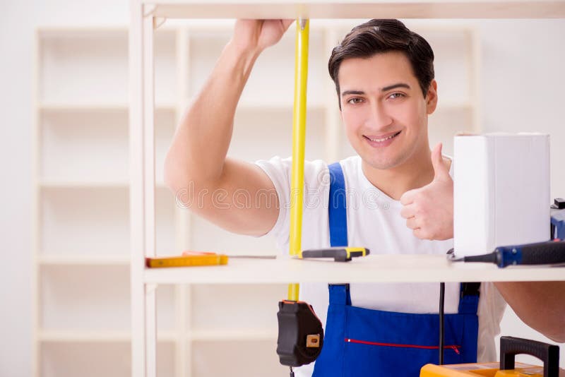 The worker man repairing assembling bookshelf stock photography