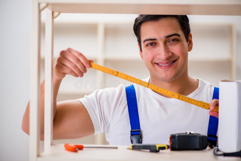The worker man repairing assembling bookshelf royalty free stock image