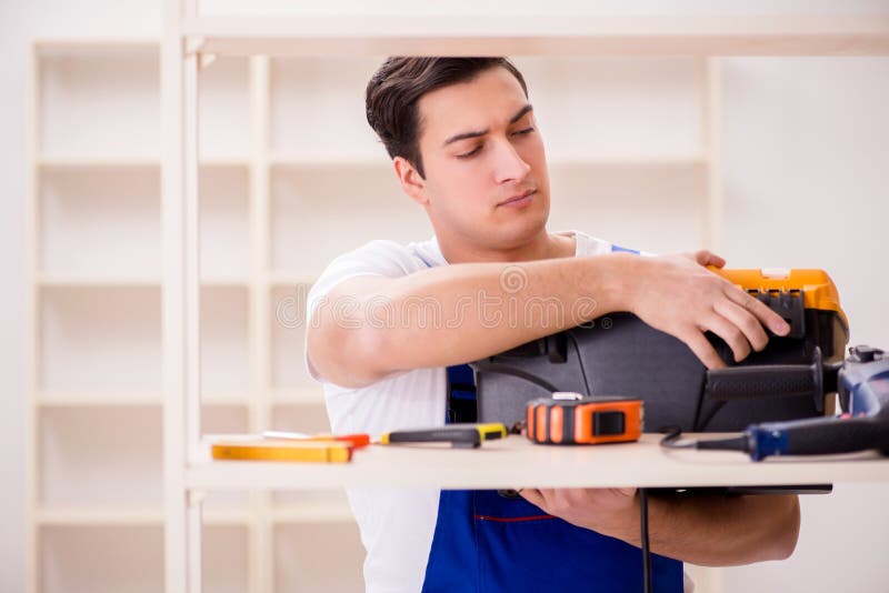 The worker man repairing assembling bookshelf royalty free stock images