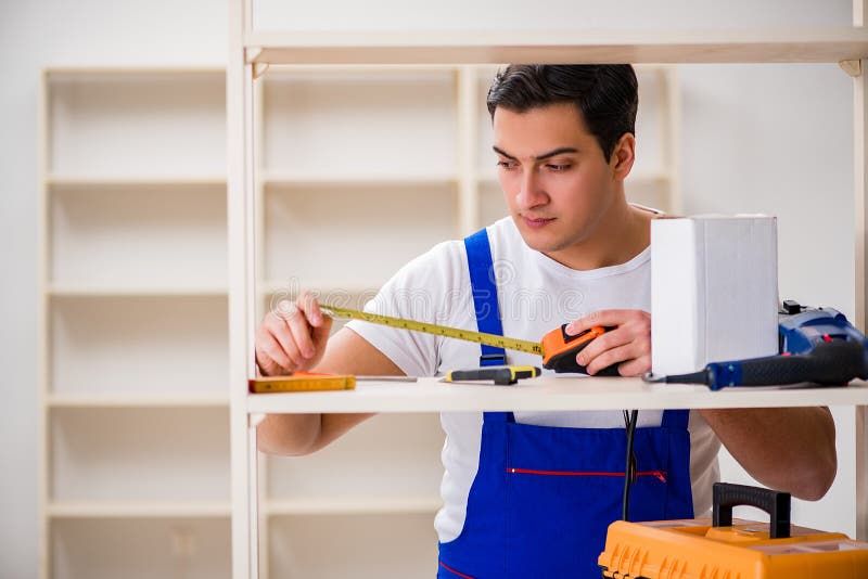 The worker man repairing assembling bookshelf stock images