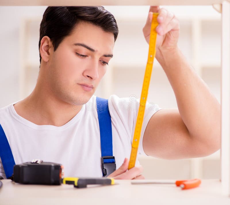 Worker man repairing assembling bookshelf stock images
