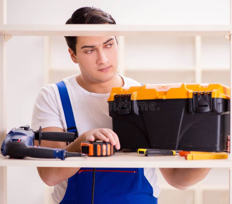 Worker man repairing assembling bookshelf royalty free stock images