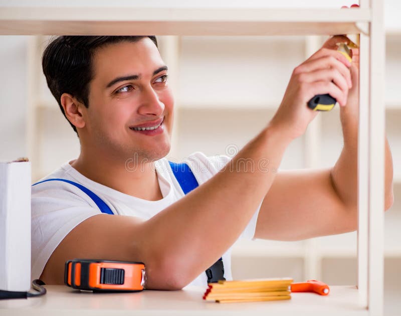 Worker man repairing assembling bookshelf stock images