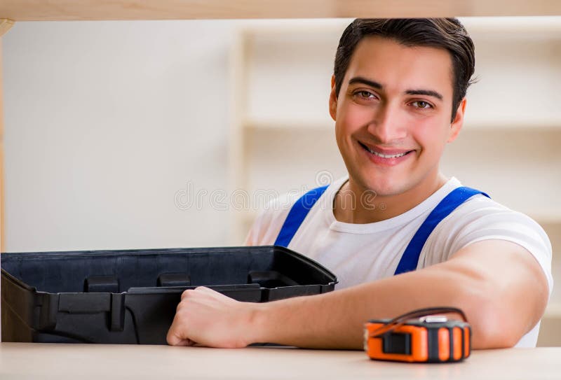 Worker man repairing assembling bookshelf stock image