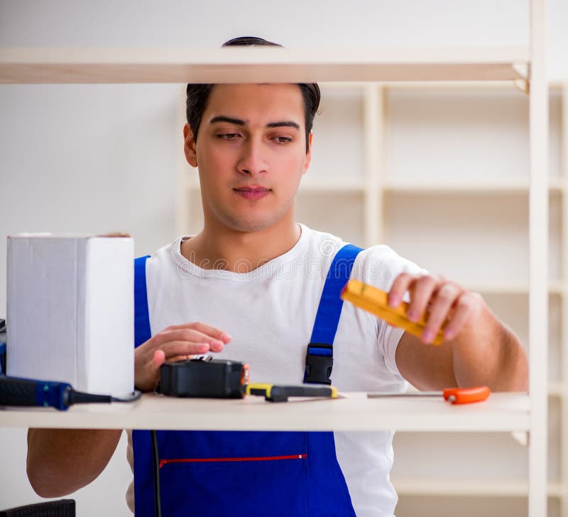 Worker man repairing assembling bookshelf royalty free stock photo