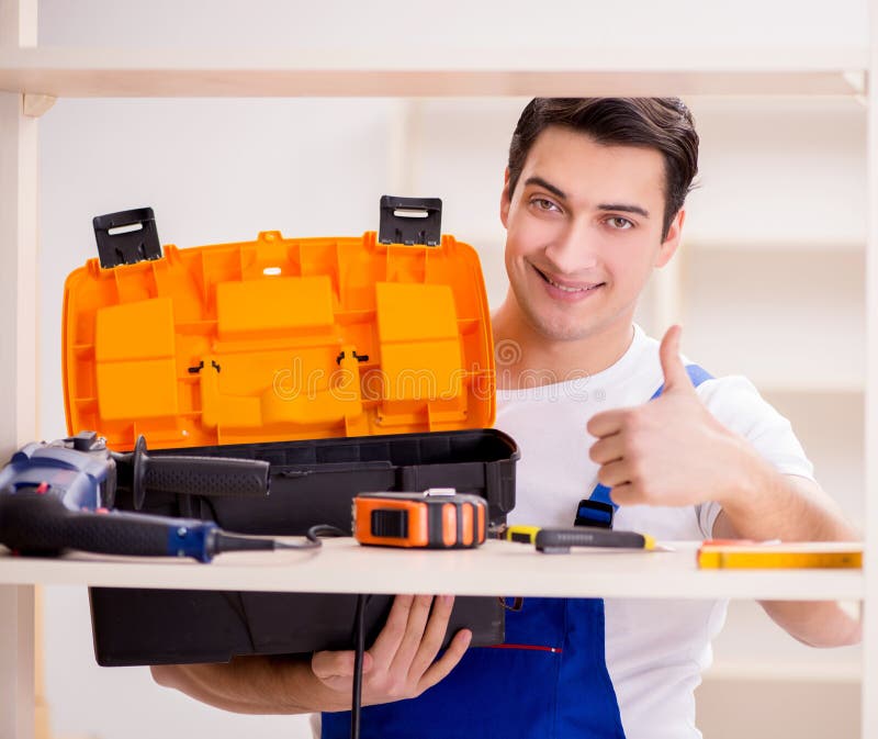 Worker man repairing assembling bookshelf royalty free stock image