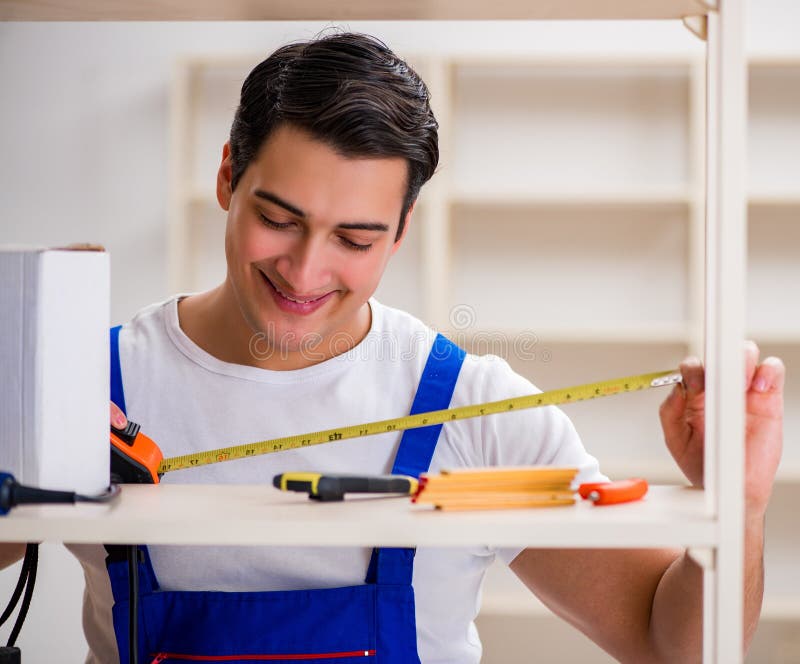 Worker man repairing assembling bookshelf royalty free stock photo