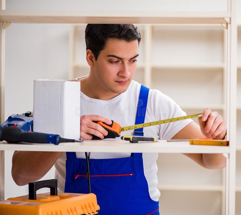 Worker man repairing assembling bookshelf royalty free stock images