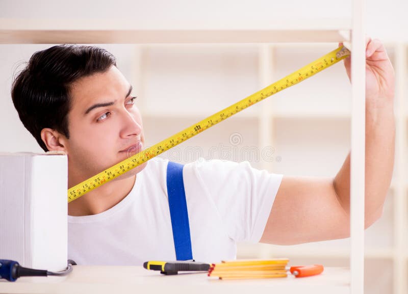Worker man repairing assembling bookshelf stock photography