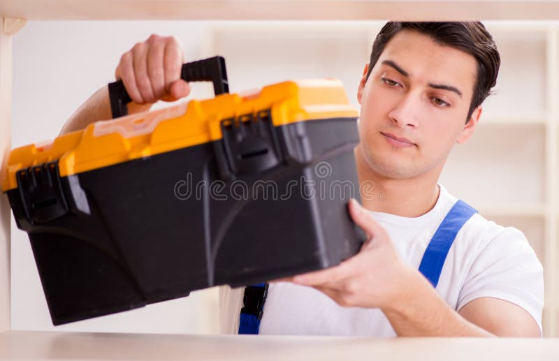 Worker man repairing assembling bookshelf royalty free stock image