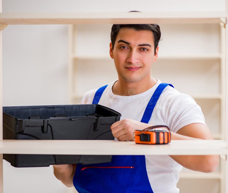 Worker man repairing assembling bookshelf royalty free stock photos