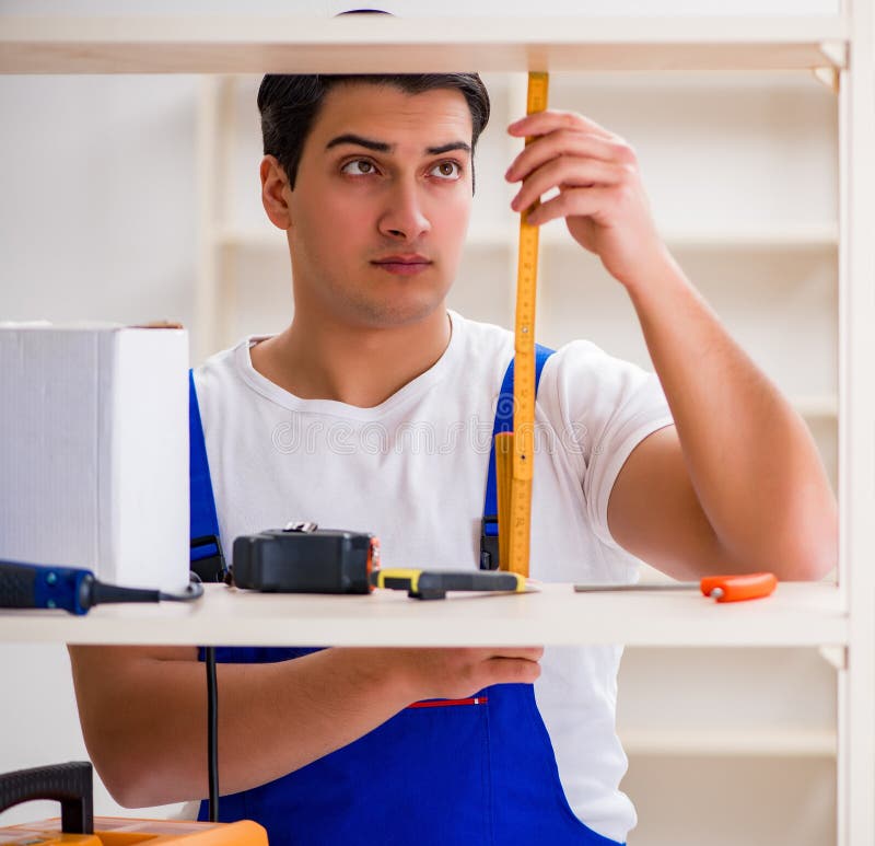Worker man repairing assembling bookshelf stock photo