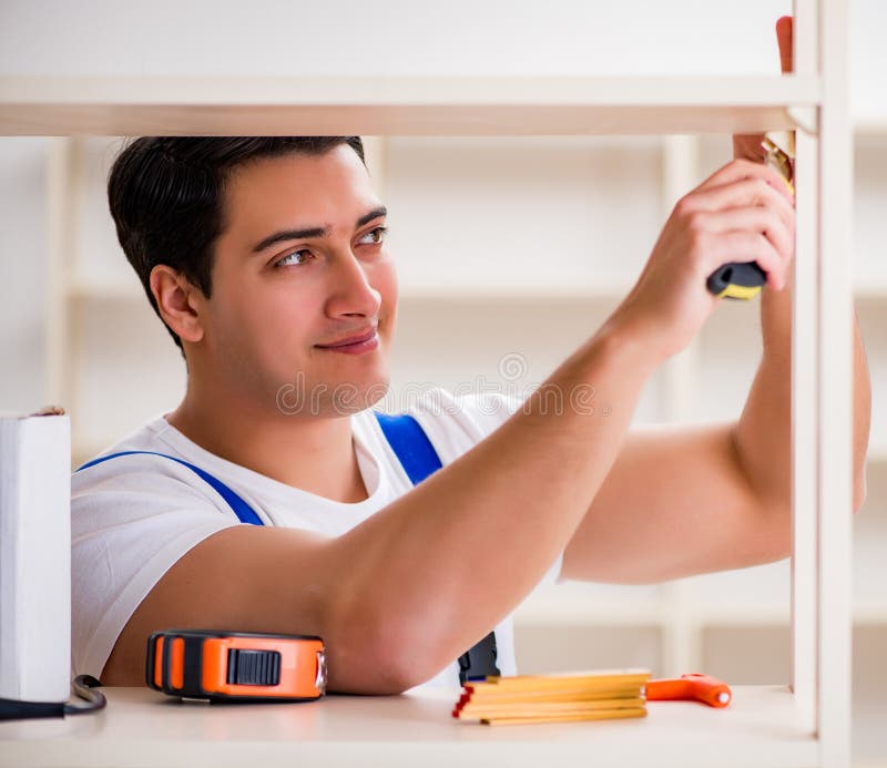 Worker man repairing assembling bookshelf stock image