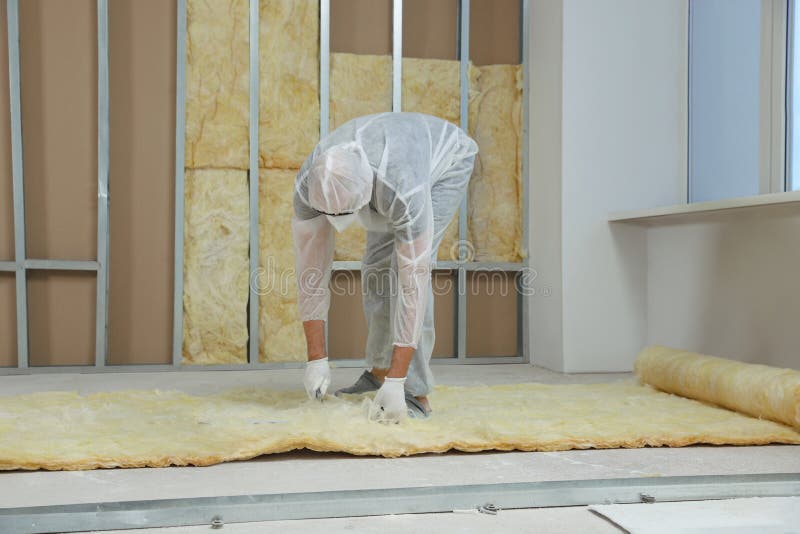 Worker measuring and cutting insulation material indoors royalty free stock photo